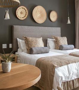 a bedroom with two beds and a wooden table at Monte Vista Boutique Hotel in Montagu