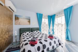 1 dormitorio con 1 cama en blanco y negro con cortinas azules en Luxury villa Nika with pool near the beach, extra pool heating available, en Medulin