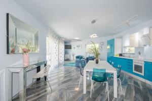 una cocina con armarios azules y una mesa y sillas blancas. en Luxury villa Nika with pool near the beach, extra pool heating available, en Medulin