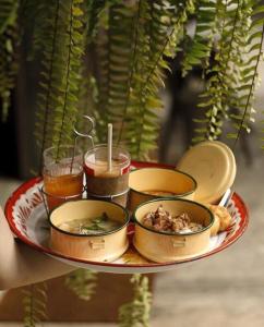 a tray with bowls of food on a plate at Inchantreedoopool in Kanchanaburi City