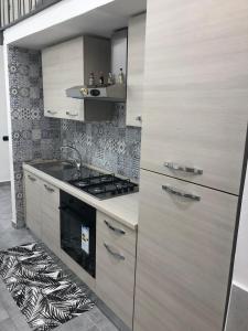 una cucina con armadi in legno e piano cottura. di Casa pallonetto a Napoli