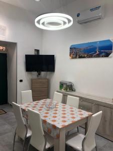 una sala da pranzo con tavolo e sedie bianche di Casa pallonetto a Napoli