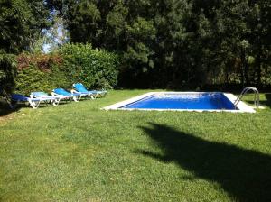 una piscina con tumbonas junto a un patio en Can Carreras, en Monells
