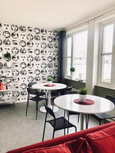 dwa stoły i krzesła w pokoju ze ścianą pokrytą talerzami w obiekcie Multi Challenge Hostel w mieście Östersund