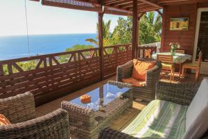 une terrasse couverte avec des chaises en osier et une table. dans l'établissement Maison à Saint-Leu, vue panoramique sur l'océan à 2 minutes des plages, à Saint-Leu