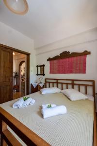 a bedroom with a bed with towels on it at Traditional Family Cretan Home! in Yerakianá