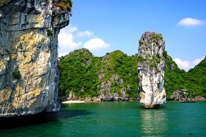 a large rock formation in the water near a beach at Alex Ha Long Hotel in Ha Long