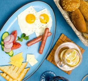 a plate of food with eggs and cheese and a hamburger at Luxury House in Shymkent