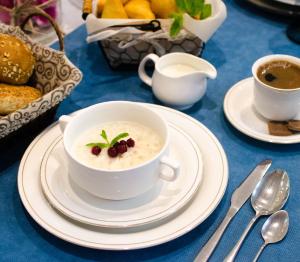 a bowl of oatmeal and a cup of coffee on a table at Luxury House in Shymkent