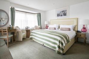 a bedroom with a large bed with a desk and a chair at Sidmouth Harbour Hotel & Spa in Sidmouth