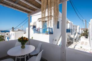 un balcone con tavolo e sedie e vista sulla città di Madres Houses a Mykonos Città