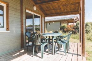 un patio con mesa y sillas en un porche en Terres de France - Les Hameaux de Pomette, en Marminiac