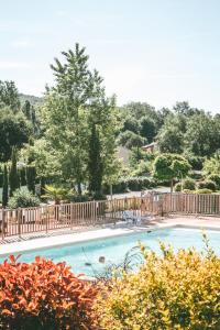 a large swimming pool with a wooden fence at Terres de France - Les Hameaux de Pomette in Marminiac