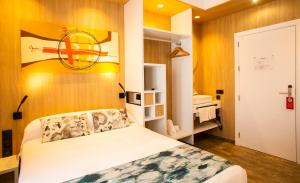 セビリアにあるHostal Sevilla Santa Justa - Adults onlyのベッドと壁に絵が飾られた寝室