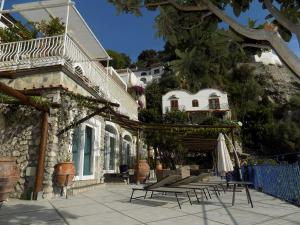een gebouw met een stel stoelen en een paraplu bij Maison de charme Villa Mavi in Praiano