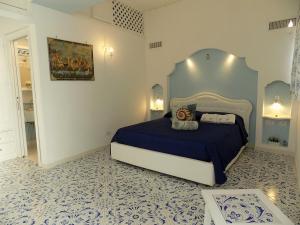 een slaapkamer met een blauw en wit bed in een kamer bij Maison de charme Villa Mavi in Praiano