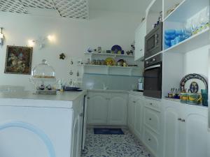 een witte keuken met witte kasten en een magnetron bij Maison de charme Villa Mavi in Praiano +115 foto's