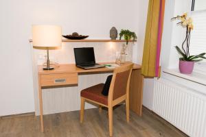 uma secretária com um computador portátil e uma cadeira num quarto em Ferienwohnungen - Boarding Wohnungen Sonnenhof em Lenzing