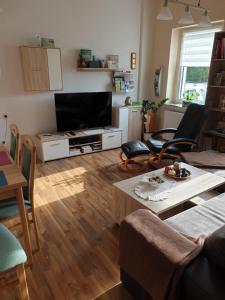 a living room with a flat screen tv and a table at Ferienwohnung Wendehake in Quedlinburg