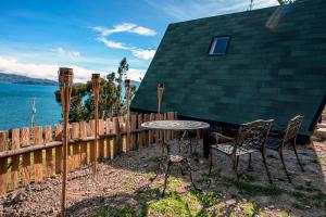 una mesa y sillas frente a una casa en La Quinta Glamping - Lago de Tota, en Cuítiva