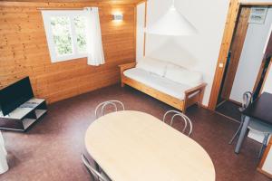 Habitación con mesa, banco y ventana en Terres de France - Les Hameaux de Miel en Beynat