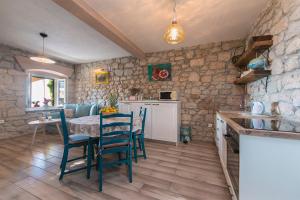 a kitchen with a table and chairs in a room at Mala Cele in Podgora