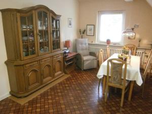 un comedor con un armario de porcelana y una mesa en Ferienwohnung An der Schlier, en Neuental