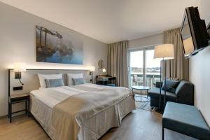 una habitación de hotel con una cama grande y una silla en Tyrifjord Hotell, en Vikersund