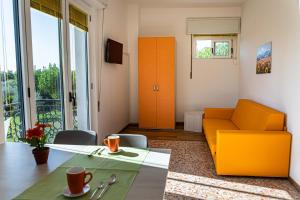 Camping Zocco في مانربا ديل جاردا: غرفة معيشة مع أريكة برتقالية وطاولة