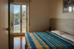 Camping Zocco في مانربا ديل جاردا: غرفة نوم بسرير وباب زجاجي منزلق