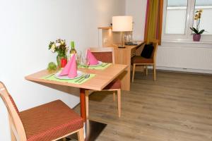 a dining room table with pink napkins on it at Ferienwohnungen - Boarding Wohnungen Sonnenhof in Lenzing