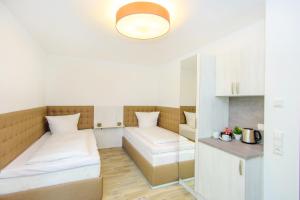 a small room with two beds and a table at Hotel Filderhof Reutlingen in Reutlingen