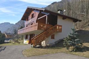 a house with a deck on the side of it at Two Bedroom Apartement Belle Vue in La Chapelle-dʼAbondance