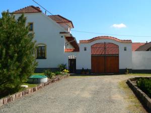 a white house with a gate and a driveway at Blažkův Statek in Malšice