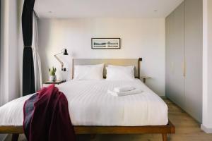 a bedroom with a large white bed with white sheets at The Interlock Apartments - Oxford St in London