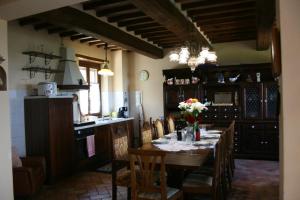 una sala da pranzo con tavolo e una cucina di Casetta i Ciliegi a Cortona
