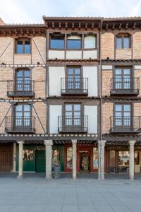 an old brick building with windows and balconies at Apartamentos Ejemplares in Alcalá de Henares