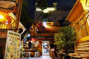 a street at night with a restaurant and a building at DDM House in Bangkok