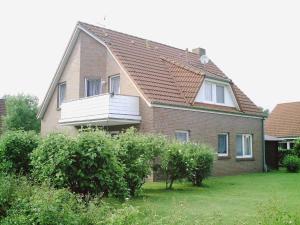una casa con un balcón en el lateral. en Komfortable Ferienwohnung am Ditzumer Sieltief, 45019, en Jemgum