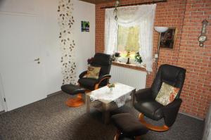 Cette chambre est dotée de chaises, d'une table et d'un mur en briques. dans l'établissement Ferienwohnung Am Königsmoor, 65323, à Moormerland