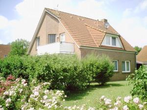 una casa con un jardín delante de ella en Komfortable Ferienwohnung am Ditzumer Sieltief, 45019, en Jemgum