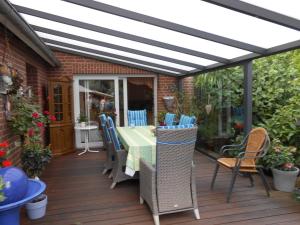 un patio con mesa y sillas en una terraza en Ferienwohnung Brentano_ 65230, en Moormerland