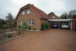 a brick house with a car parked in the garage at Ferienwohnung Brentano_ 65230 in Moormerland