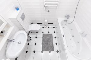 uma casa de banho branca com uma banheira, um WC e um lavatório. em Apartamenty Granitica Zakopane em Zakopane