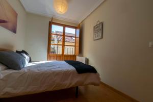 1 dormitorio con cama y ventana en Duplex completo junto a la Plaza Mayor en Salamanca