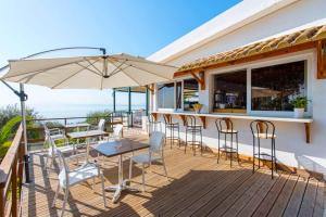 a patio with a table and chairs and an umbrella at Nissaki Suite Kalypso in Nisaki