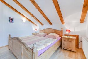um quarto com uma cama de madeira e uma mesa de cabeceira em Katharinenhof Ferienwohnung Hausberg (6) em Garmisch-Partenkirchen