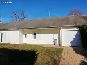 a white house with a large garage at Les Fauvettes in Ouzouer-sur-Loire