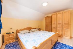 - une chambre avec un grand lit et des placards en bois dans l'établissement APARTMENTS ROGLA LUKANJA 1, à Oplotnica