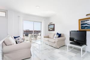 a living room with two couches and a flat screen tv at Home2Book Stunning Sea Views Adeje, Wifi & Pool in Playa Fañabe